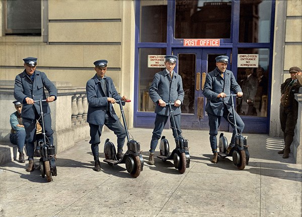 1917年、新たに配備されたスクーターとともに写真に写る配達員