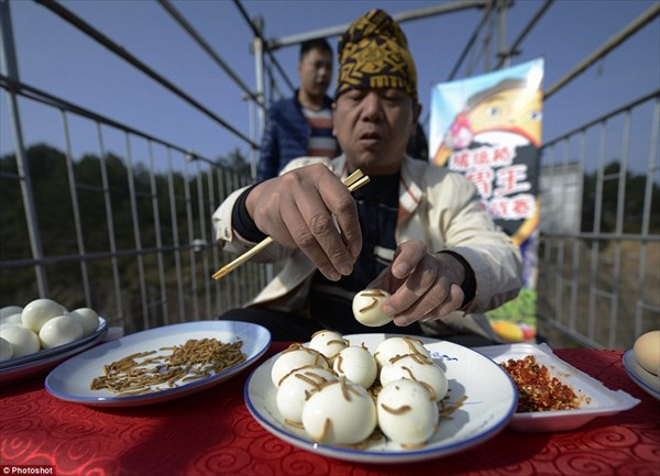 中国の大食い王、ガラスのつり橋の上でゆで卵36個と、大量のミルワームを完食
